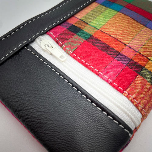 A mini zippered coin purse made from a patchwork of different materials: multicolor checkered madras and black lambskin leather.