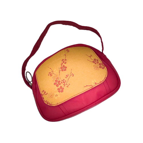A mini handbag made of yellow upholstery fabric with a red cherry blossom pattern and red leather.