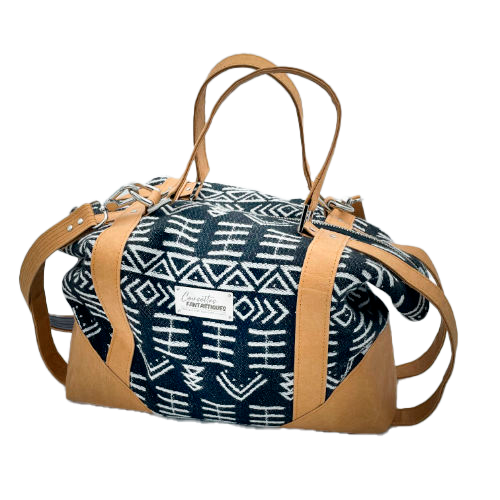 A small travel bag made of washable caramel paper, a black and white geometric patterned babywearing wrap, and grey poplin.
