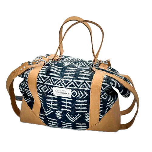 A small travel bag made of washable caramel paper, a black and white geometric patterned babywearing wrap, and grey poplin.