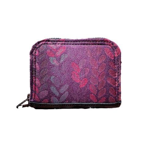 A small zippered card and coin holder made of fabric in shades of purples, crimsons, pinks... with a droplet pattern.
