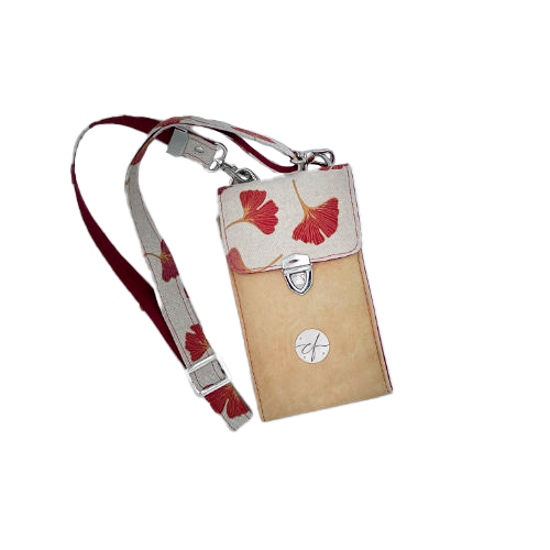 A phone-purse made from camel colored leather and a red Ginkgo Biloba leaves patterned polycotton canvas.