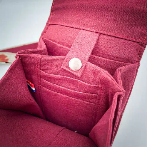 A phone-purse made from camel colored leather and a red Ginkgo Biloba leaves patterned polycotton canvas.