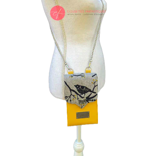 A phone-purse made from a gray, navy blue, and yellow babywearing scarf with bird motifs, and sun-yellow faux leather.