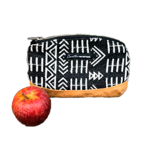 A small zippered clutch made of washable caramel paper, a black and white geometric patterned babywearing wrap, and grey poplin.
