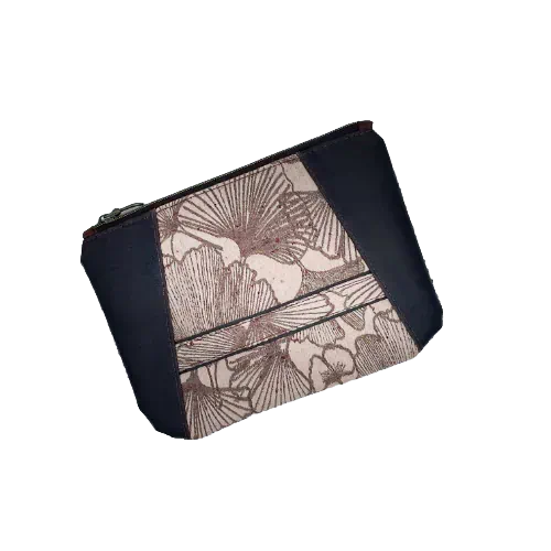 A zipped pouch sewn in a dappled brown skin and a babywearing wrap in a Ginkgo Biloba pattern, brown on a powder pink background