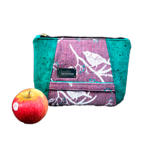 A zippered pouch sewn from a mauve and green babywearing wrap with a bird motif on branches, combined with emerald green cork.