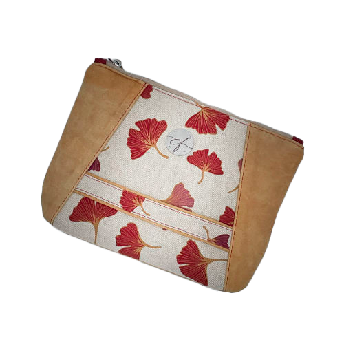 A zippered pouch sewn from a camel colored leather and a red Ginkgo Biloba leaves patterned polycotton canvas.