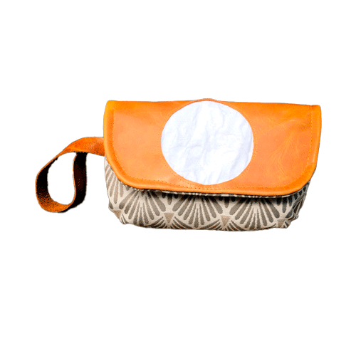 A flap clutch sewn in caramel leather, white damask, and vintage beige and gray patterned fabric, lined with taupe canvas.