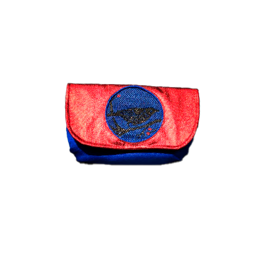 A small flap clutch sewn in blue canvas, metallic red-coated denim, and a glittery avian patterned babywearing wrap, lined with golden satin.