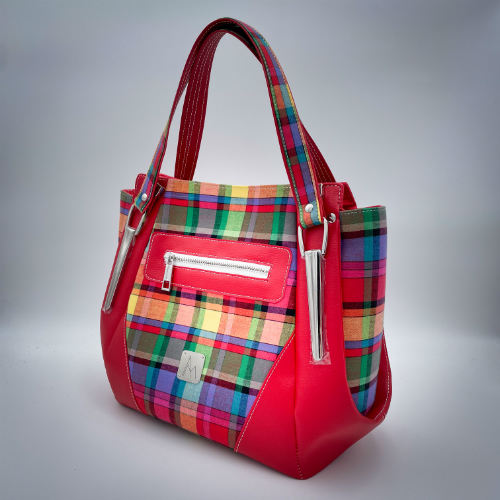 A shoulder bag made of blood-red faux leather and multicolored madras fabric.