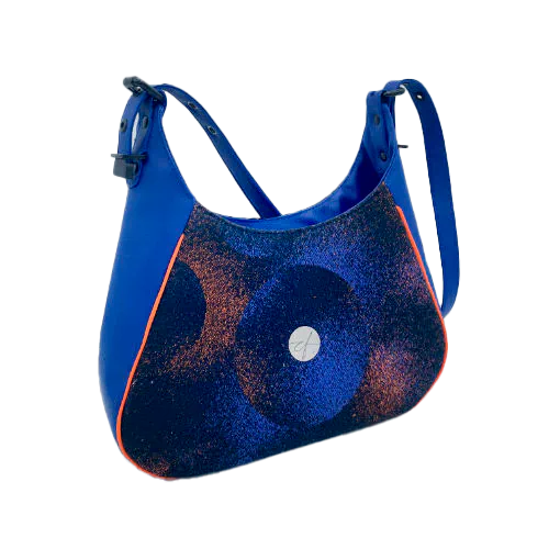 A zippered shoulder bag made from black, blue, pink and orange babywearing wrap scrap, royal blue faux leather, and bright light orange lining.
