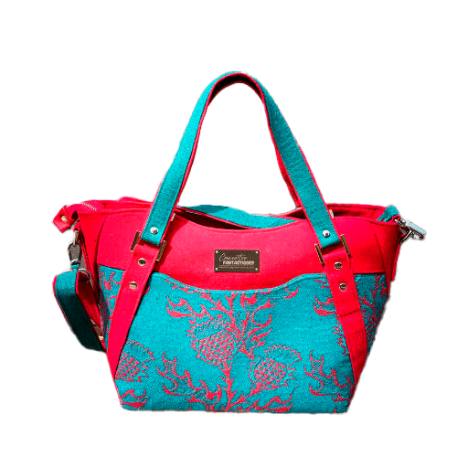 A shoulder bag made from blood red and emerald green babywearing wrap with a thistle pattern, red gabardine, emerald green linen, and synthetic material.