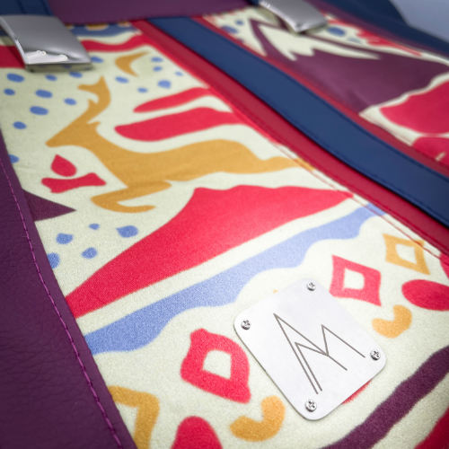 A shoulder bag made from a silk scarf with Scandinavian folklore patterns, combined with red, blue, and purple faux leathers.