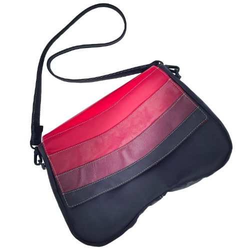 A shoulder bag made of leathers in different shades of red, with brown accents and a red lining.