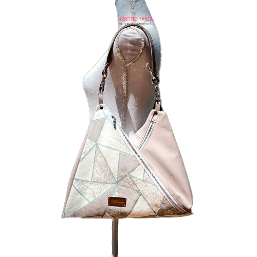 A triangular shoulder bag made of beige synthetic leather and white, cream, beige, and green babywearing fabric.