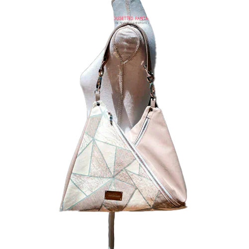 A triangular shoulder bag made of beige synthetic leather and white, cream, beige, and green babywearing fabric.