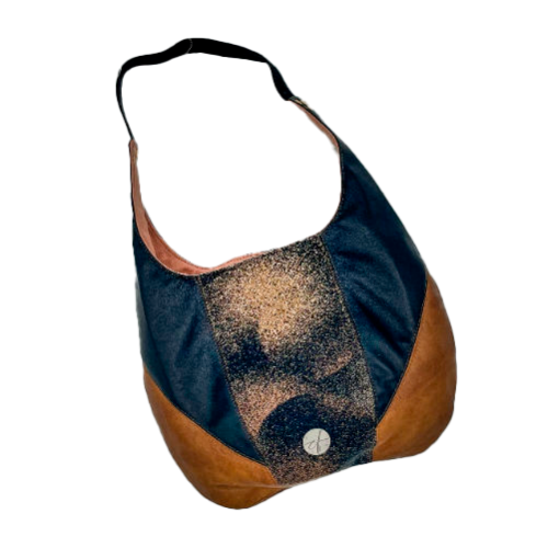 A shoulder bag made of brown and black leathers, a black, brown, and beige babywearing wrap with a round abstract pattern, and peach linen canvas.
