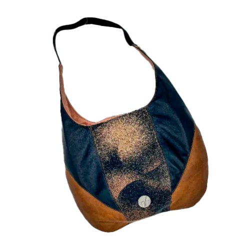 A shoulder bag made of brown and black leathers, a black, brown, and beige babywearing wrap with a round abstract pattern, and peach linen canvas.