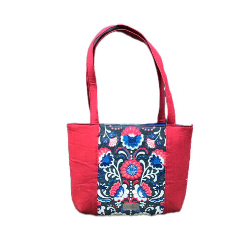 A tote bag made from gray fabric embroidered with blue, red, and white Scandinavian floral motifs, red gabardine, and royal blue poplin.