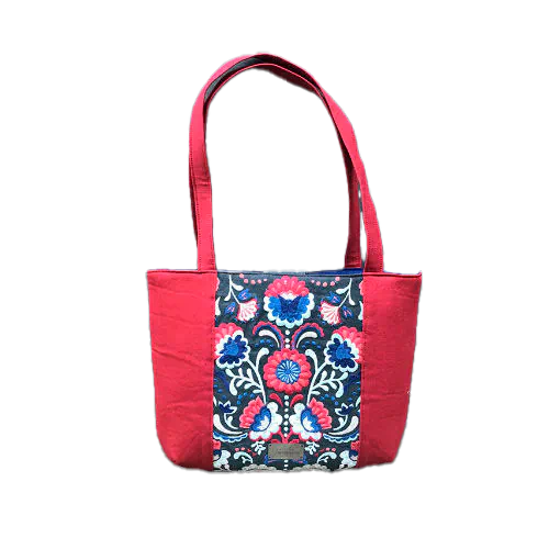 A tote bag made from gray fabric embroidered with blue, red, and white Scandinavian floral motifs, red gabardine, and royal blue poplin.