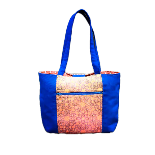 A tote bag made from royal blue fabric, a babywearing wrap with an Arabesque geometric pattern in blue on a gradient background from orange to yellow, and orange cretonne with geometric patterns.