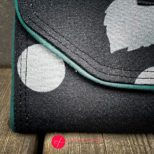 A wallet made from black and white floral silk chiffon on the outside and black poplin on the inside.