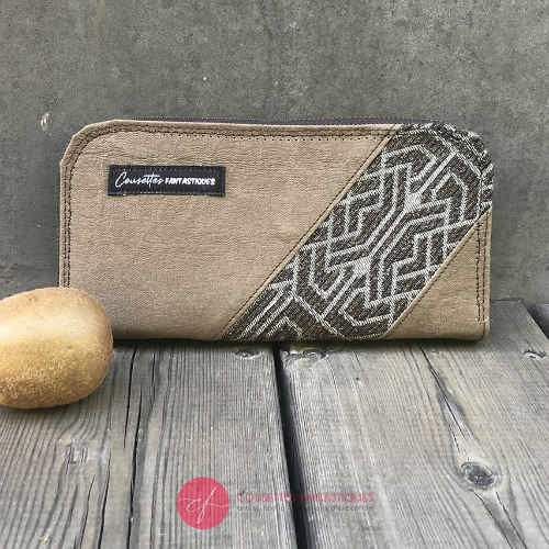 A zippered card and coin holder made with gray lamb leather, upholstery fabric, and raw linen canvas.