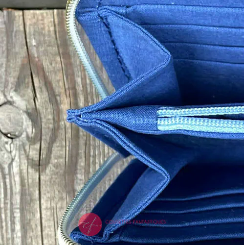 A zippered card and coin holder made with rainbow gradient babywearing scarf with pointillist star motif and gray high-couture denim.