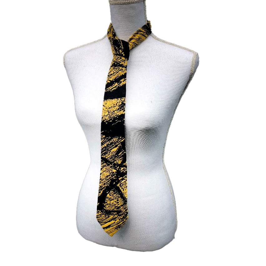 A tie made from black and gold woven wrap, marbled pattern.