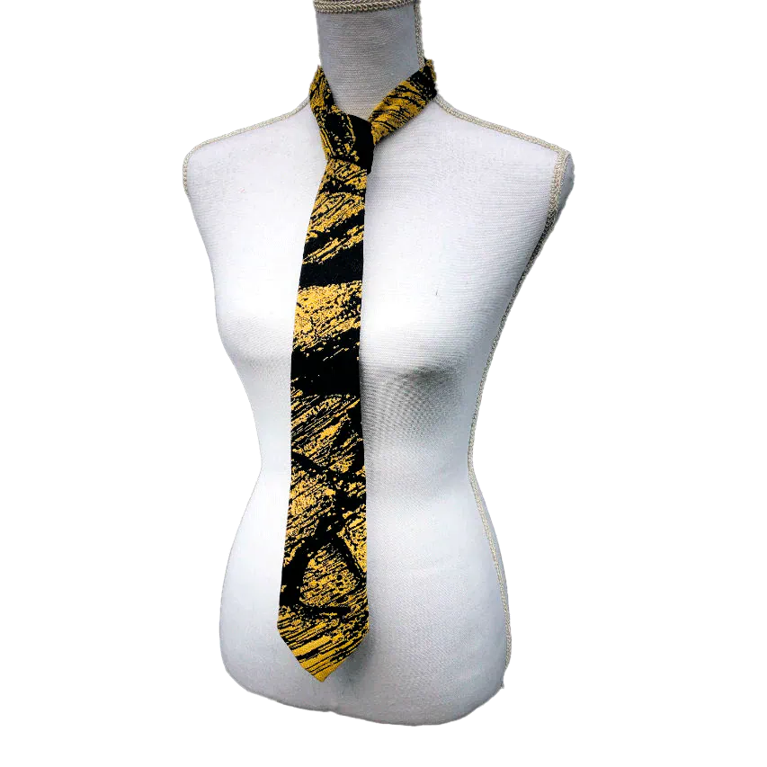 A tie made from black and gold woven wrap, marbled pattern.