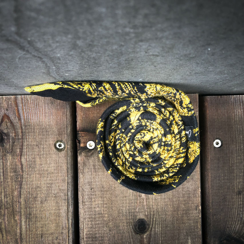 A tie made from black and gold woven wrap, marbled pattern.