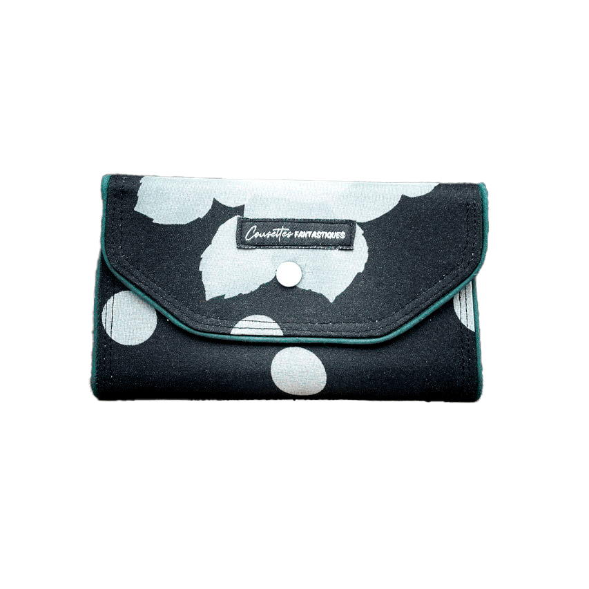 A wallet made from black and white floral silk chiffon on the outside and black poplin on the inside.