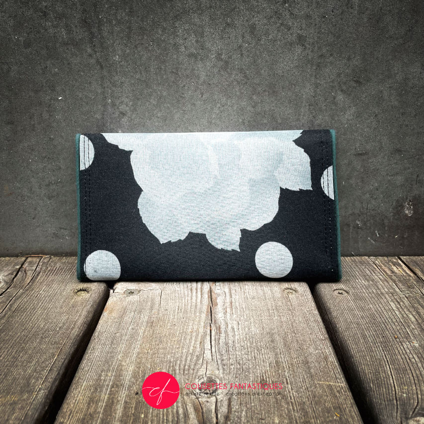 A wallet made from black and white floral silk chiffon on the outside and black poplin on the inside.