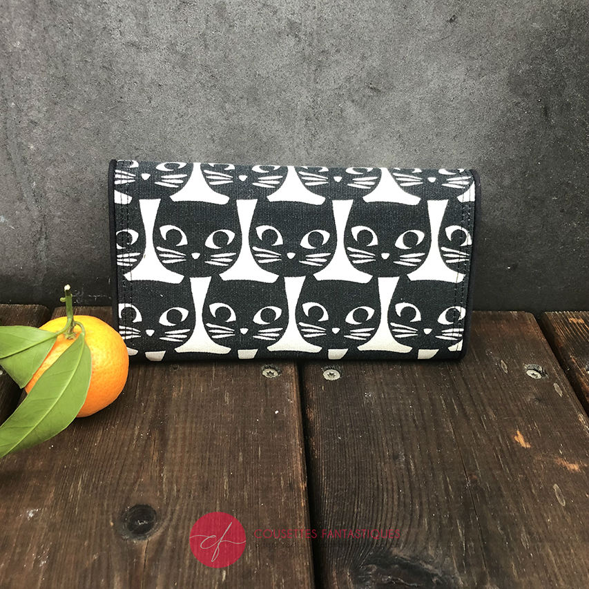 A wallet made from black and white 100% cotton canvas on the outside and pink poplin and bird-patterned cretonne on the inside.