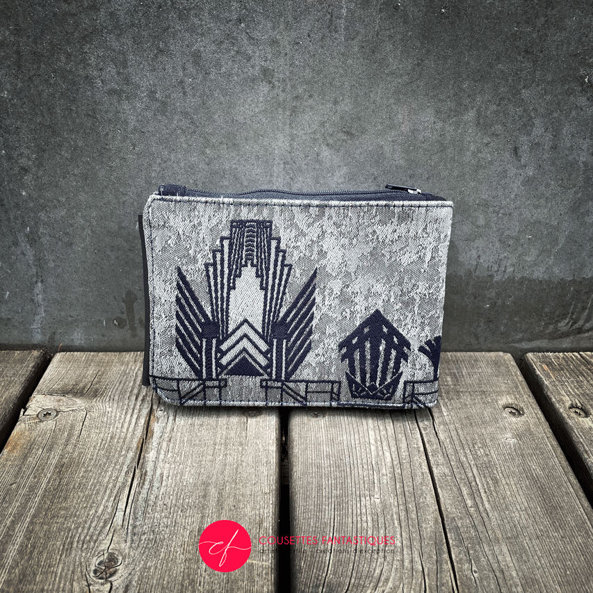 A wallet made from a midnight blue and silver geometric Art Deco patterned babywearing wrap, in midnight blue leather, midnight blue gabardine, and mouse gray poplin.