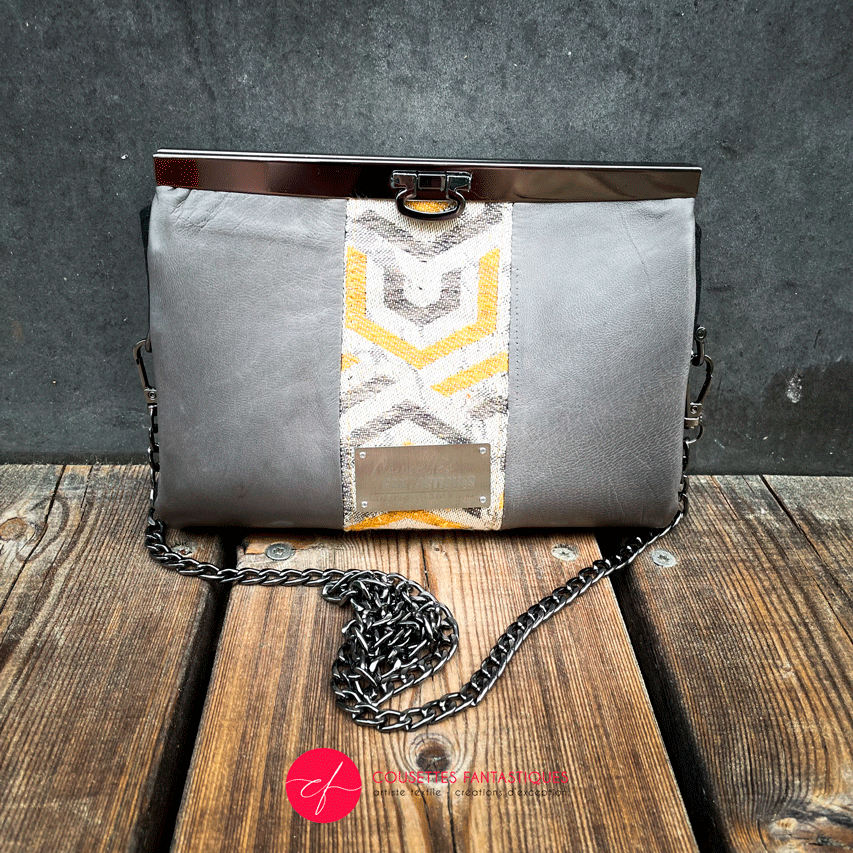 A companion made from a gray, mustard, and ecru babywearing wrap with geometric patterns and gray lambskin leather.