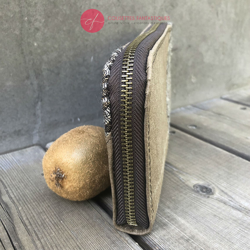 A zippered card and coin holder made with gray lamb leather, upholstery fabric, and raw linen canvas.