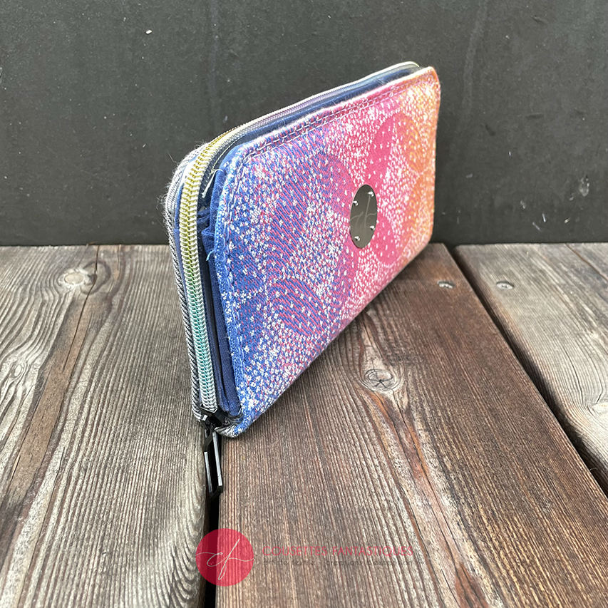 A zippered card and coin holder made with rainbow gradient babywearing scarf with pointillist star motif and gray high-couture denim.