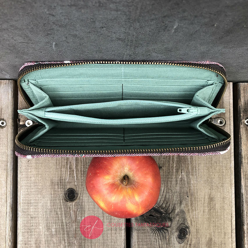 A zippered card and coin holder made with mauve and green bird-patterned babywearing wrap fabric.