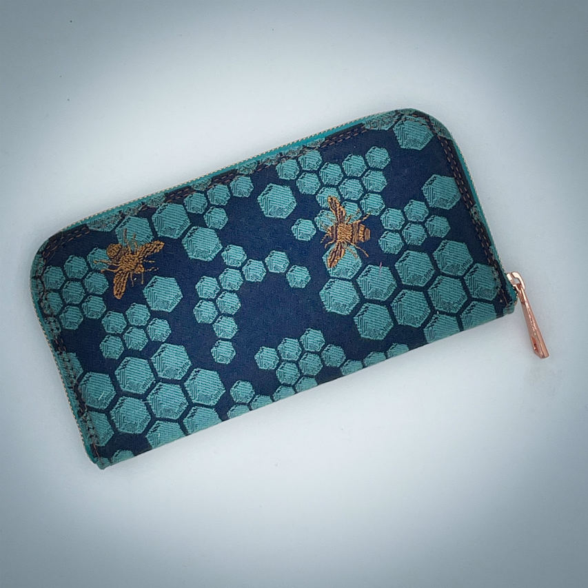 A zippered card and coin holder made with dark blue and petrol blue honeycomb patterned babywearing wrap fabric with bees.