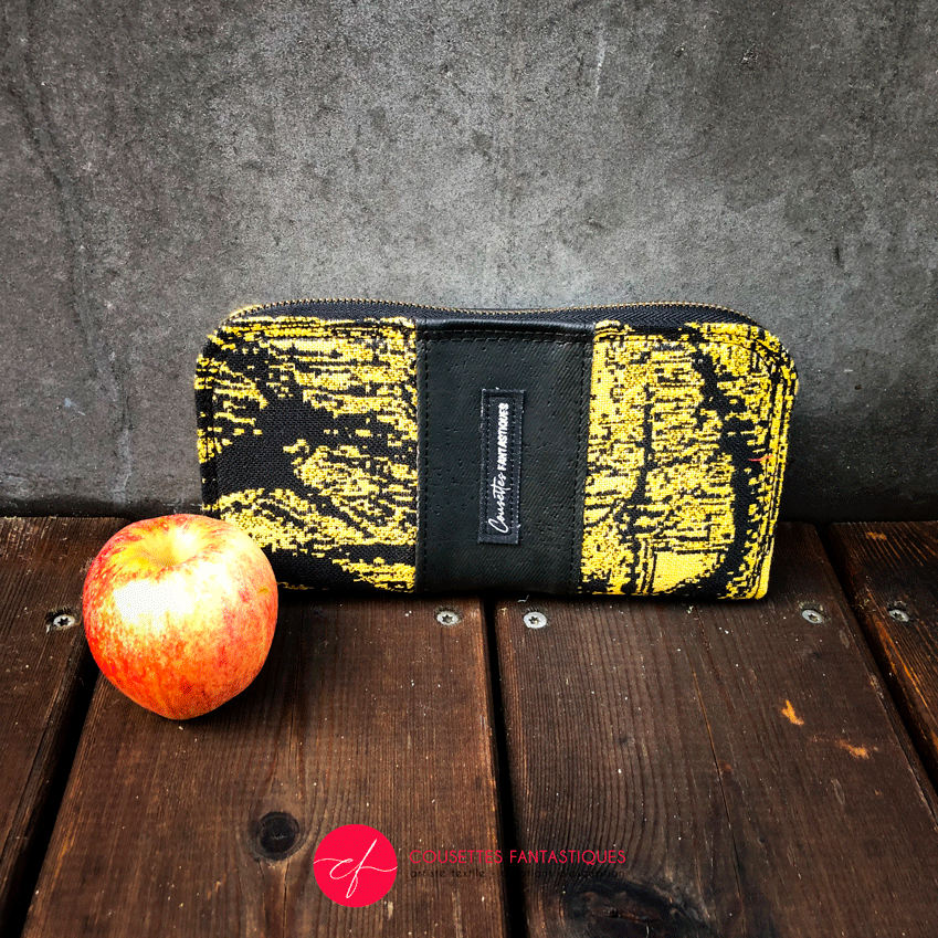 A zippered card and coin holder made with black and gold marbled babywearing wrap fabric and matte black cork.