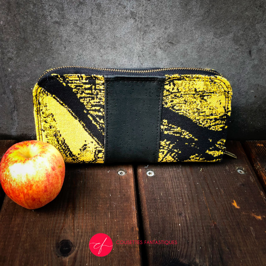 A zippered card and coin holder made with black and gold marbled babywearing wrap fabric and matte black cork.