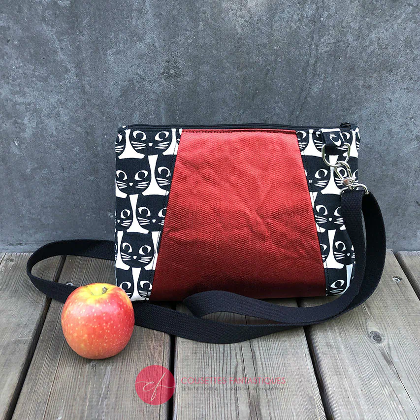 Un sac en bandoulière trapézoïdal fabriqué à partir de toile en coton noir et blanc avec des motifs stylisés de chats et d'oiseaux, assorti à de la cretonne de coton à thème aviaire à l'intérieur.