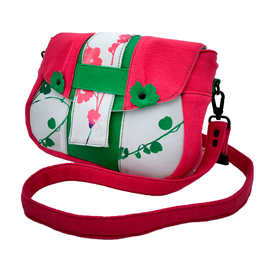 Un sac en bandoulière fabriqué à partir de néoprène aux motifs floraux, d'un crêpe rose fuschia et de cuir grainé vert vif.