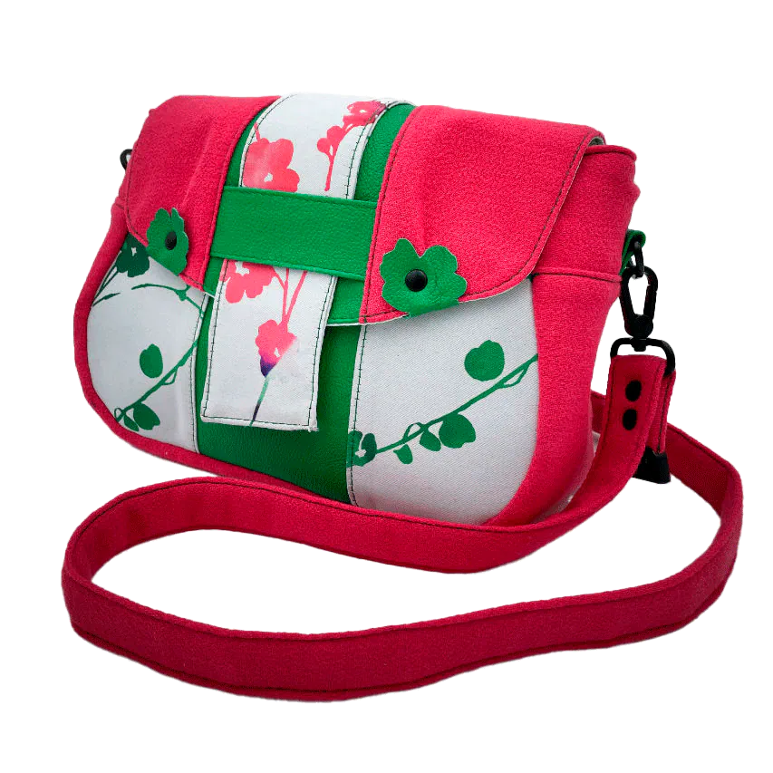 Un sac en bandoulière fabriqué à partir de néoprène aux motifs floraux, d'un crêpe rose fuschia et de cuir grainé vert vif.