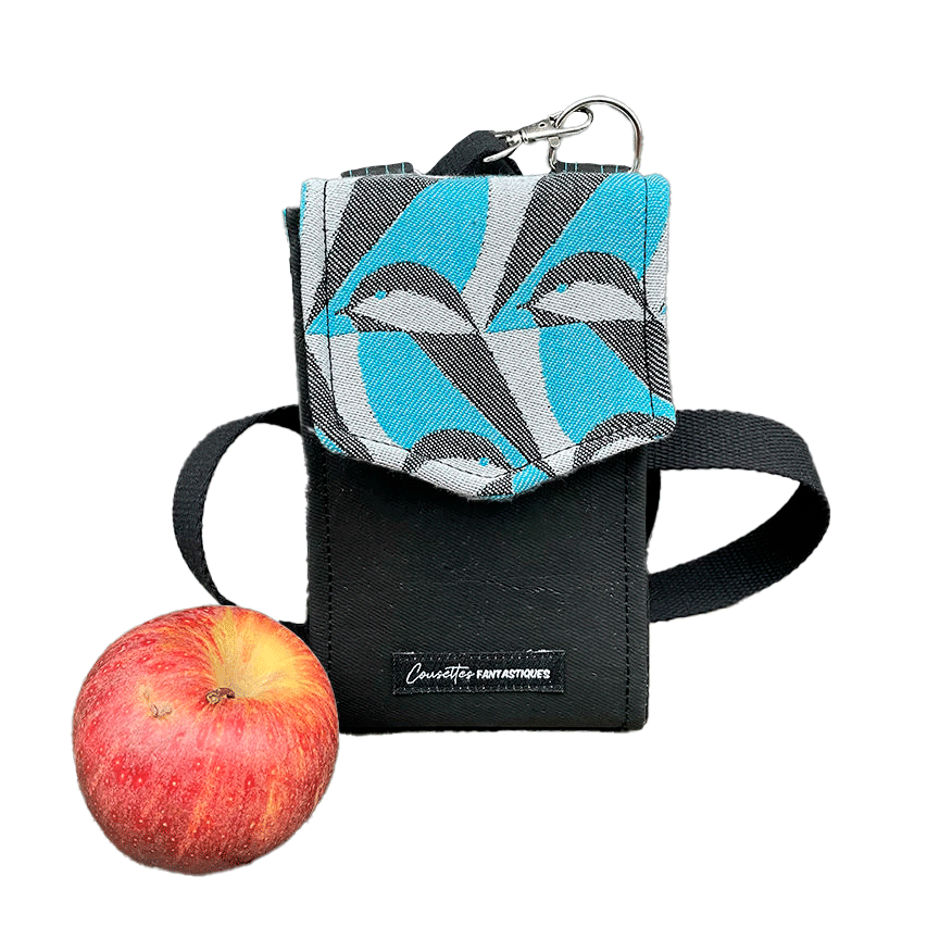 Un portefeuille-sac fabriqué à partir d'une écharpe de portage grise, noir et bleu ciel avec des motifs stylisés de tête de moineau, et du liège noir.