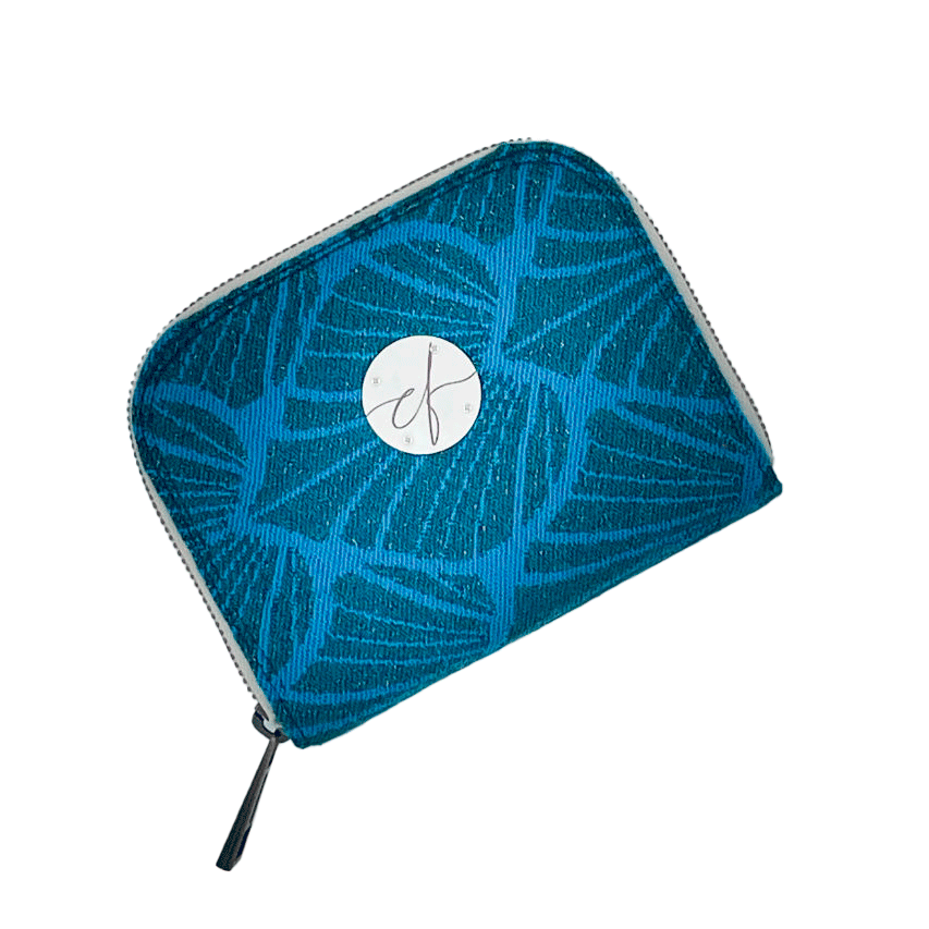 Un porte-cartes-et-monnaie zippé fabriqué avec un coupon d'écharpe de portage à motif de feuilles vert forêt et turquoise avec des paillettes.