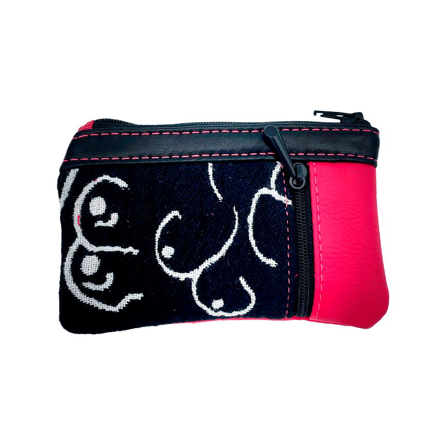 Un petit porte-monnaie zippé fabriqué à partir d'un patchwork de différents matériaux : une écharpe de portage noir et blanc avec un motif stylisé de seins, du cuir d'agneau noir et du simili fuchsia.