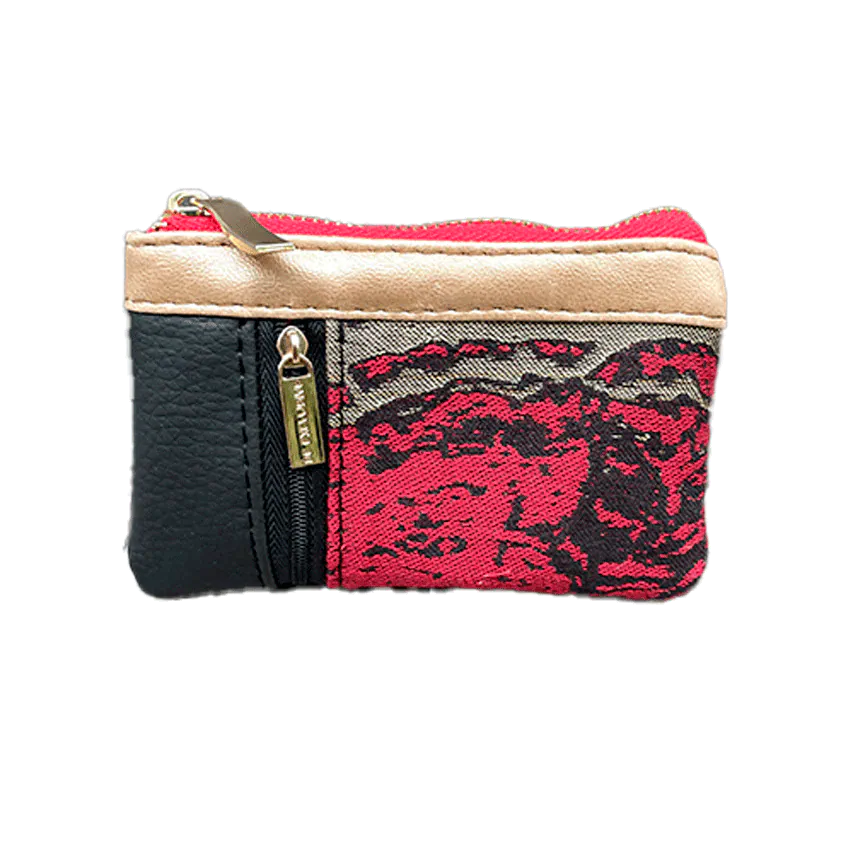 Un petit porte-monnaie zippé fabriqué en simili noir, or et rouge, et un tissu en écharpe de portage assortie avec un motif marbré.